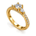 Round moissanite three-stone engagement ring with pear side stones and pavé band, angled view