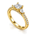 Princess Cut moissanite three-stone engagement ring with pear side stones and pavé band, angled view